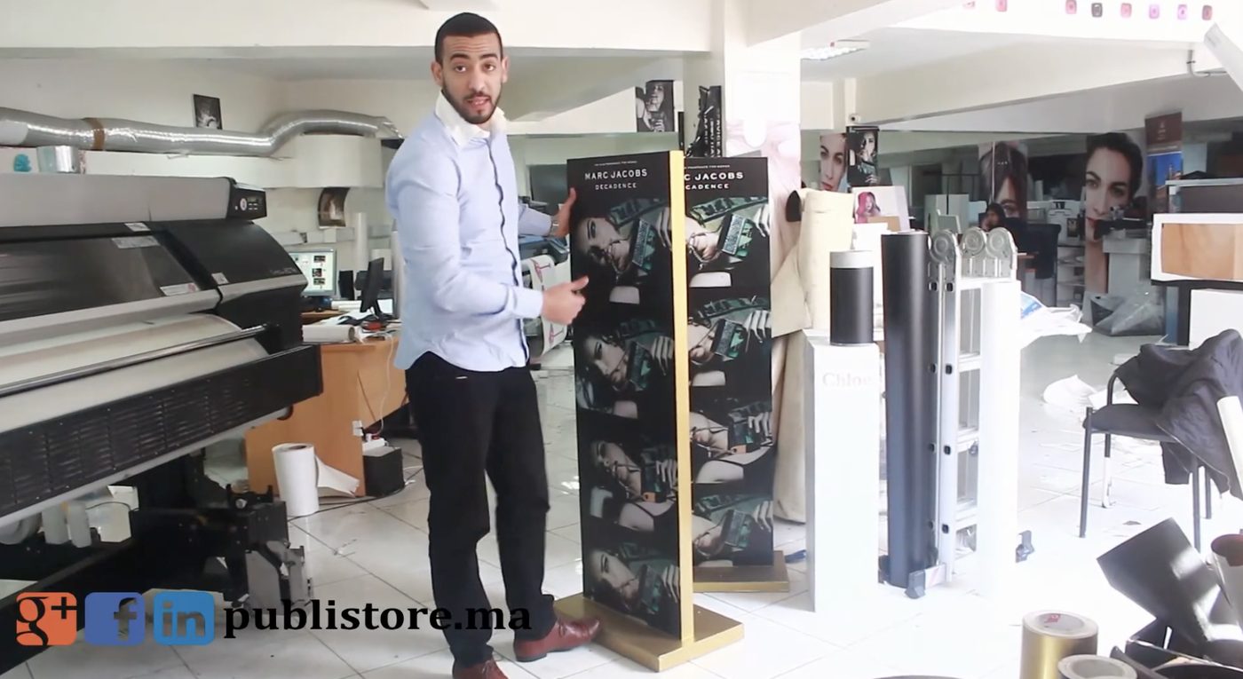 Chouaib Rahmouni dans les locaux de Publistore, devant une imprimante grand format